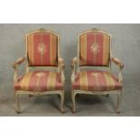 A pair of French Louis XV style grey painted beech fauteuil armchairs, with a ribbon carved crest,