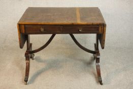 A George III mahogany and crossbanded sofa table with two drop leaves and two drawers, on end