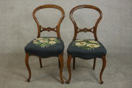 A pair of Victorian walnut ballon back dining chairs, upholstered with embroidered white flowers