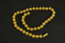 A vintage knotted amber bead necklace with hidden barrel clasp. (string broken) L.67cm.