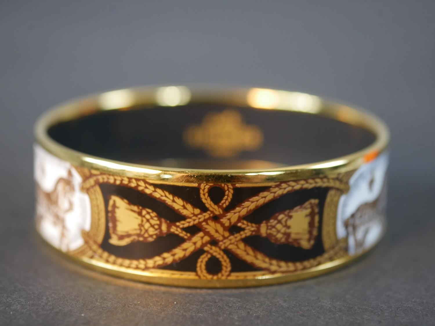 A boxed Hermes black and gold horse and tassel motif cloisonne gold plated enamel bangle. Makers - Image 3 of 5