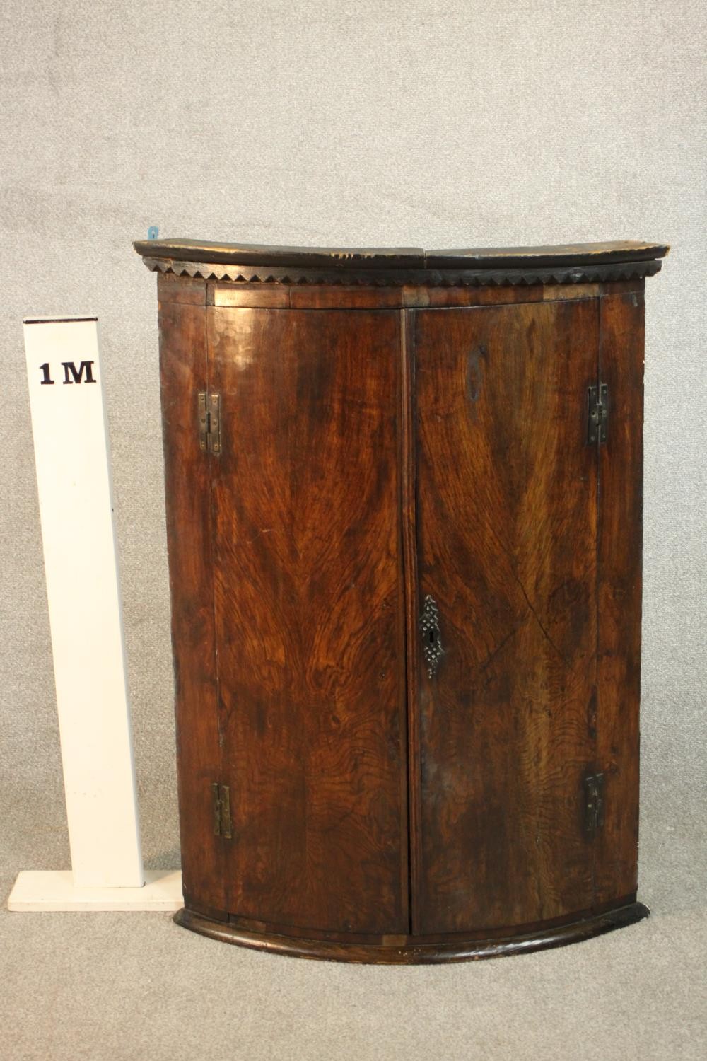 An 18th century bow front corner cabinet, with two doors enclosing shelves and three short - Image 2 of 7