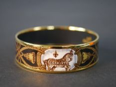 A boxed Hermes black and gold horse and tassel motif cloisonne gold plated enamel bangle. Makers