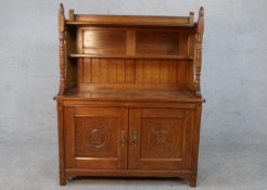 A late 19th century Arts and Crafts inspired sideboard with raised superstructure above panel