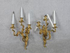 A pair of Rococo style ormolu three branch wall candelabras, wired for electricity. H.66cm