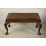 A George II style Victorian walnut stool, upholstered in brown fabric, with a gadrooned edge, on