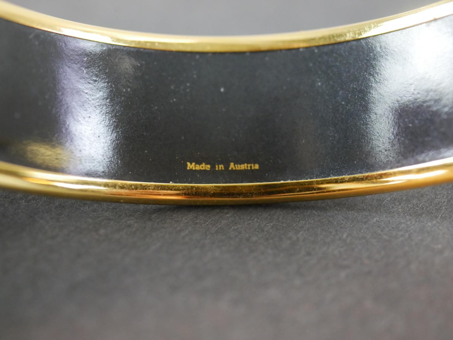A boxed Hermes black and gold horse and tassel motif cloisonne gold plated enamel bangle. Makers - Image 5 of 5