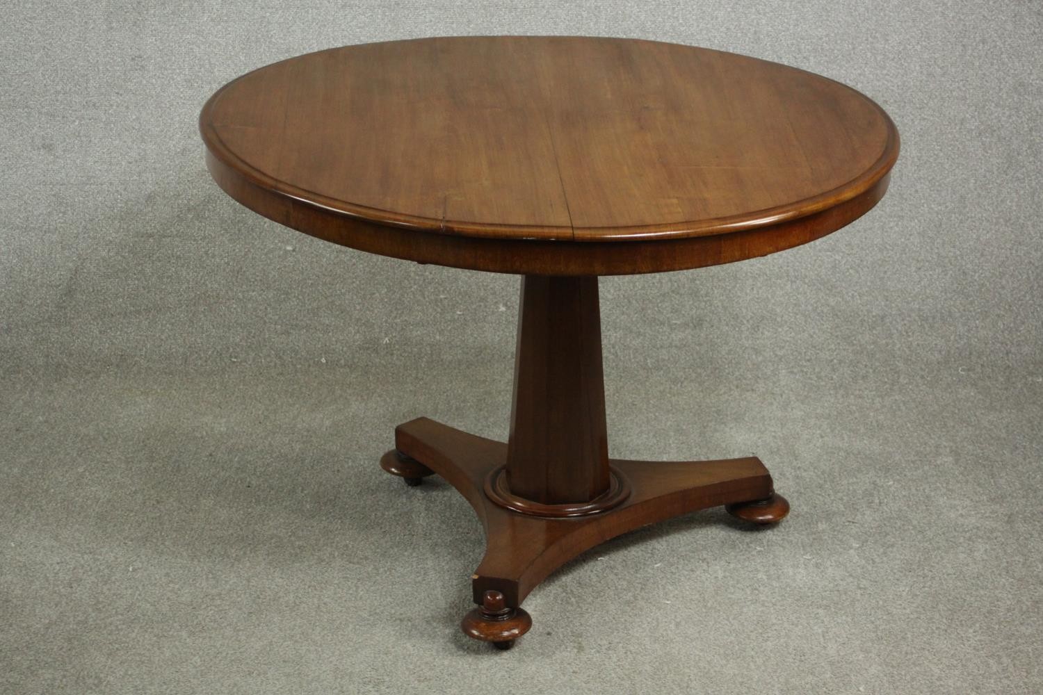 A mid 19th century walnut tilt top table, the circular top with a moulded edge, on a chamfered