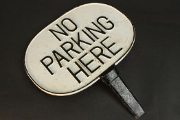 A painted cast iron 'No Parking Here' sign with relief letters and border. H.43 W.37cm.