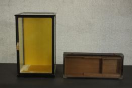 A Japanese black lacquered display cabinet, with a single glazed door, glazed to the top and the two