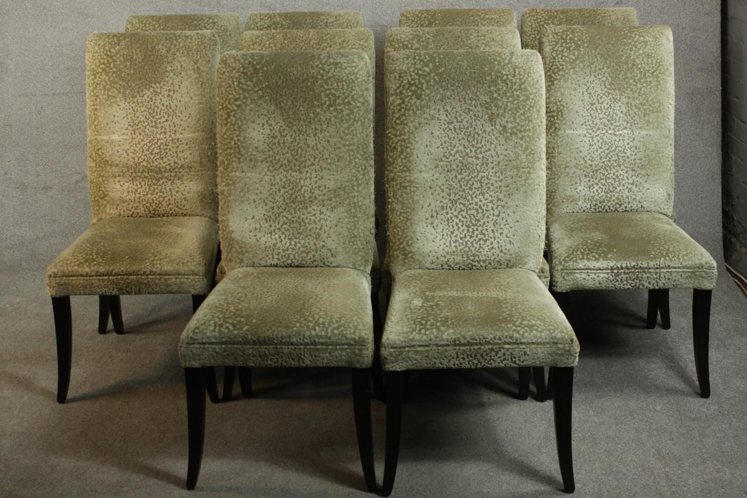 A set of ten contemporary dining chairs, upholstered in gold coloured fabric, on ebonised square