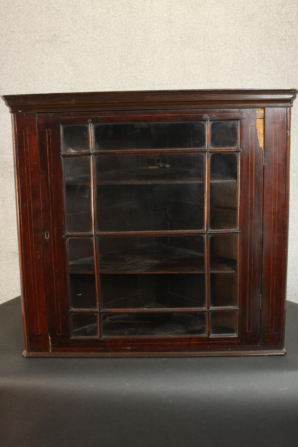 A George III mahogany corner cabinet, with a glazed door enclosing shelves. H.74 W.78 D.41cm.