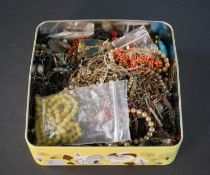 A tin box of antique and vintage jewellery and beads, including branch coral, antique glass and