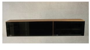 BoConcept, Denmark; a contemporary teak wall mounted media unit, with two smoked glass fall front