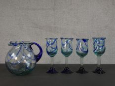 A set of four hand blown dark blue, pale blue and clear marble glass wine glasses and the matching