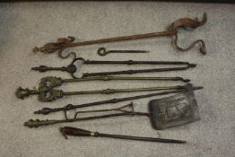 A collection of early 20th century cast iron and brass fire irons, other tools and a cast iron three