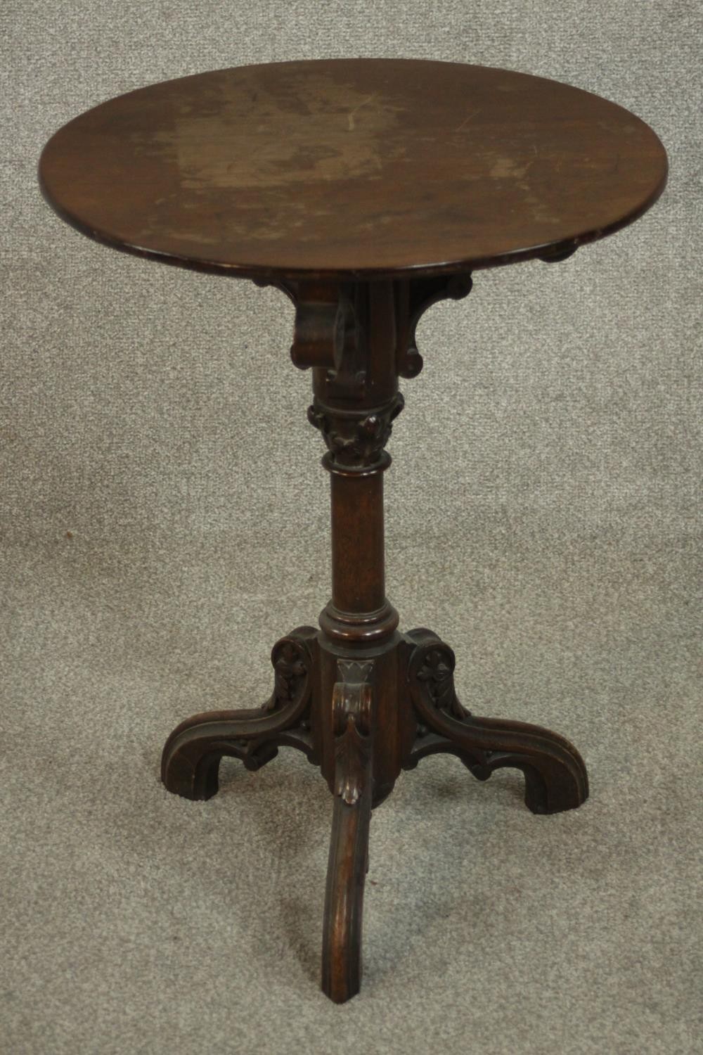 A Victorian ecclesiastical mahogany occasional table, with a circular top supported by carved