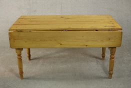 A Victorian pine drop leaf dining or kitchen table, the plank top with two drop leaves on turned