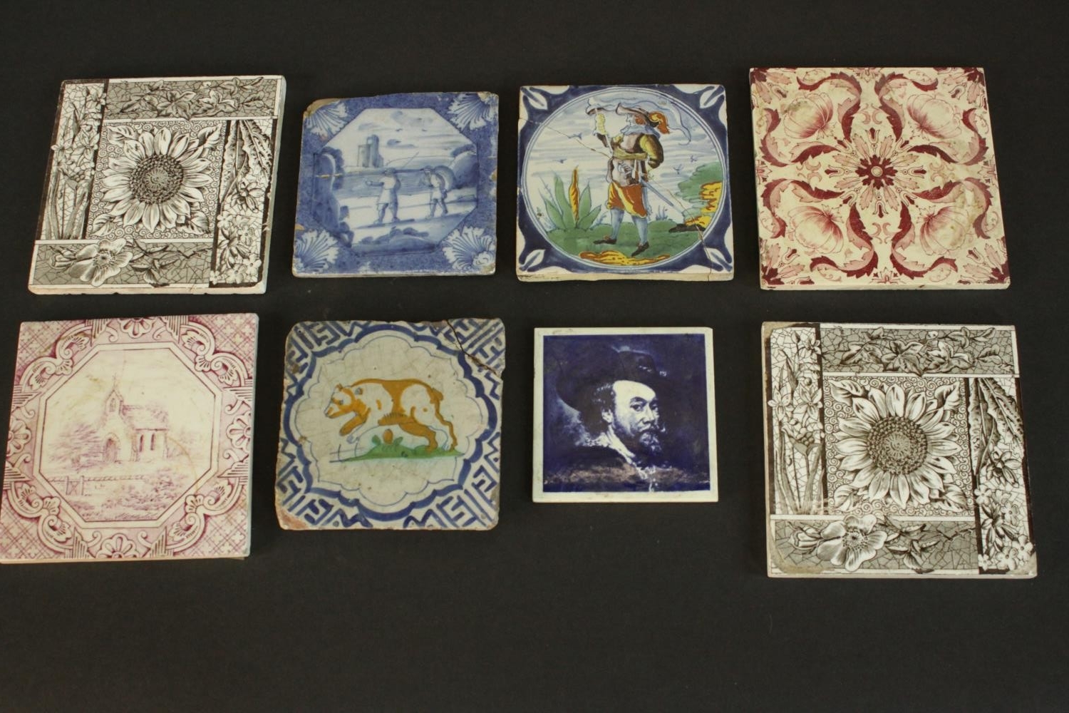 A collection of ceramic tiles, including four 19th and 20th century Delft tiles one with a