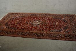 A Persian Keshan carpet with central medallion with flowerhead motifs across the madder ground