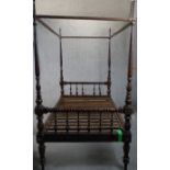 A 19th century walnut four poster single bed, the headboard and foot with turned rails, supported by