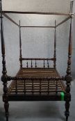 A 19th century walnut four poster single bed, the headboard and foot with turned rails, supported by