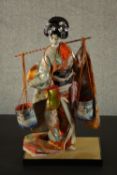 A Vintage Japanese Geisha doll in kimono and traditional dress, ceramic face, carrying a yoke with
