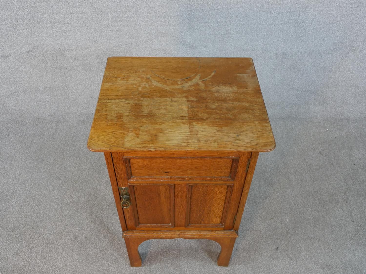 An Arts and Crafts oak bedside cabinet with panel door on shaped supports. H.73 W.45 D.39cm - Image 2 of 5