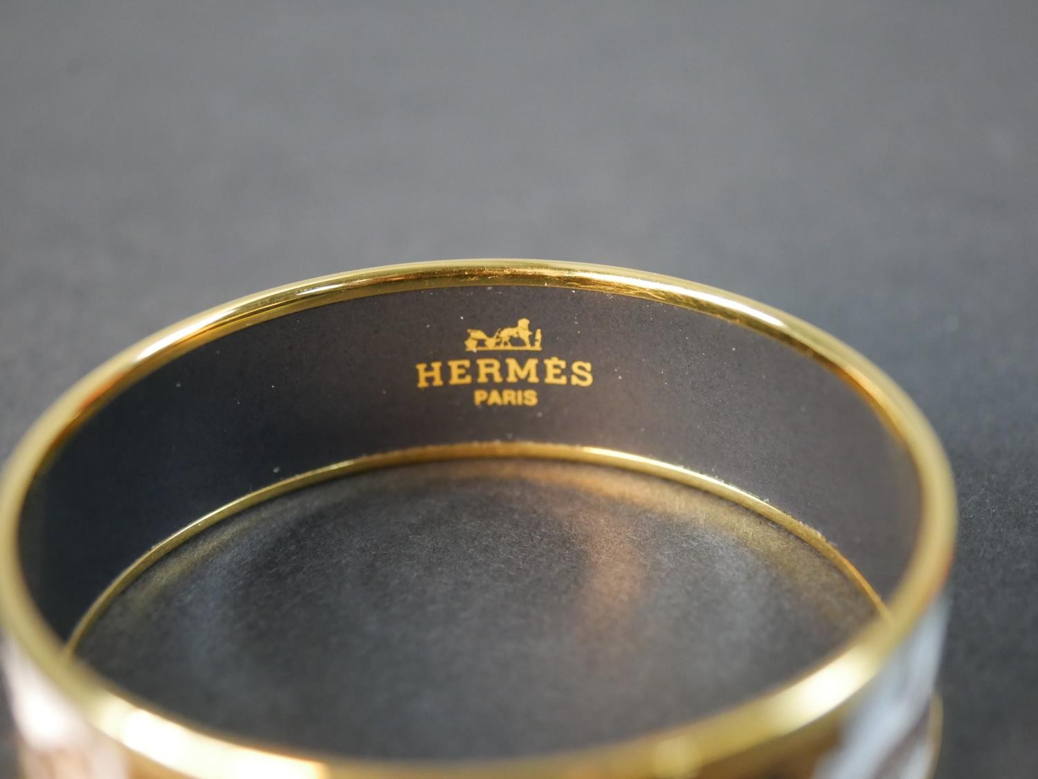 A boxed Hermes black and gold horse and tassel motif cloisonne gold plated enamel bangle. Makers - Image 2 of 5