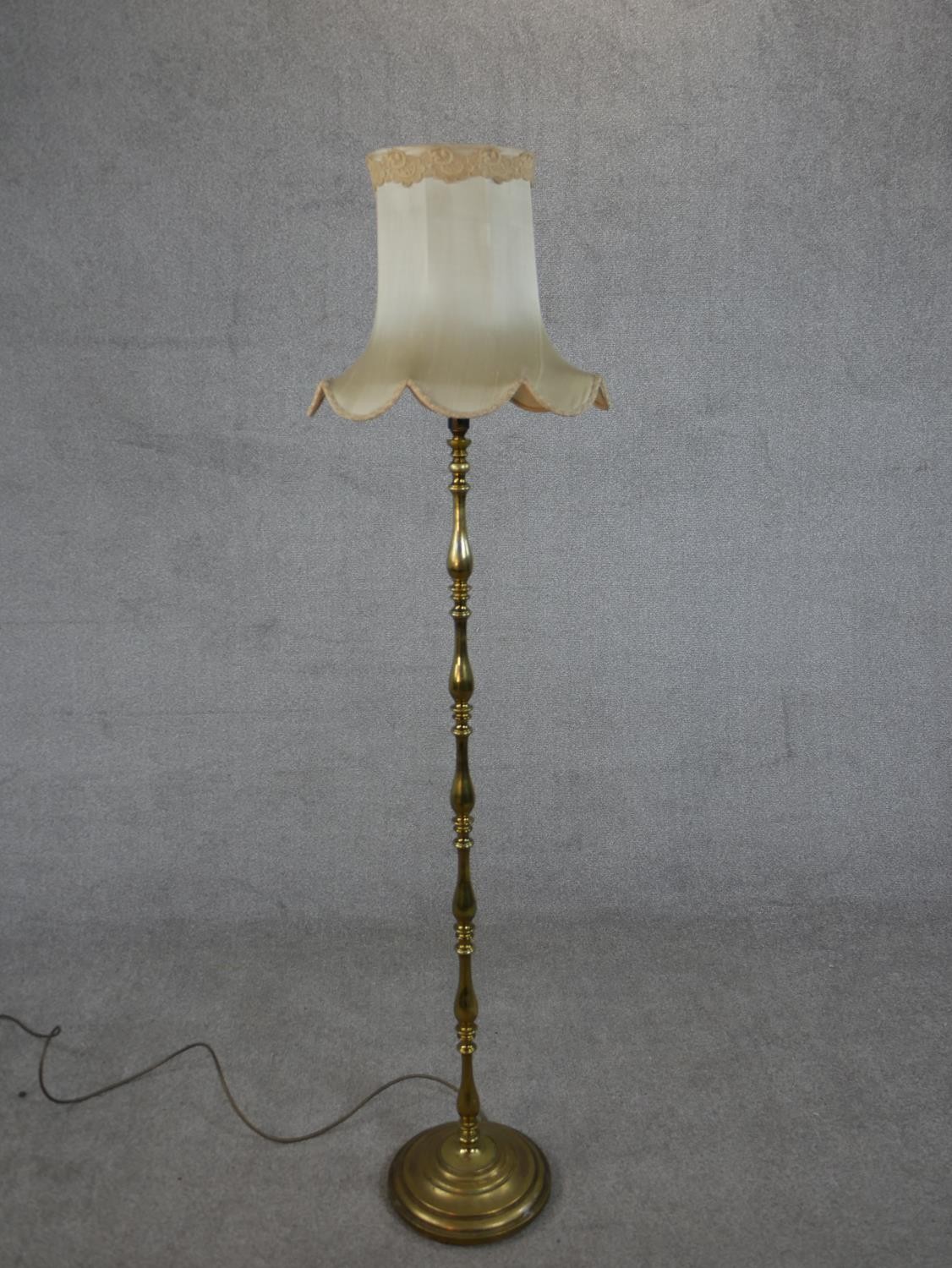 A 20th century brass standard lamp, with a multiple baluster turned stem on a circular base, with