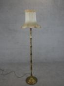 A 20th century brass standard lamp, with a multiple baluster turned stem on a circular base, with