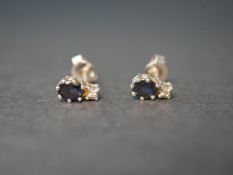 A pair of white metal (tested as 14ct gold) sapphire and diamond stud earrings. Each earring set