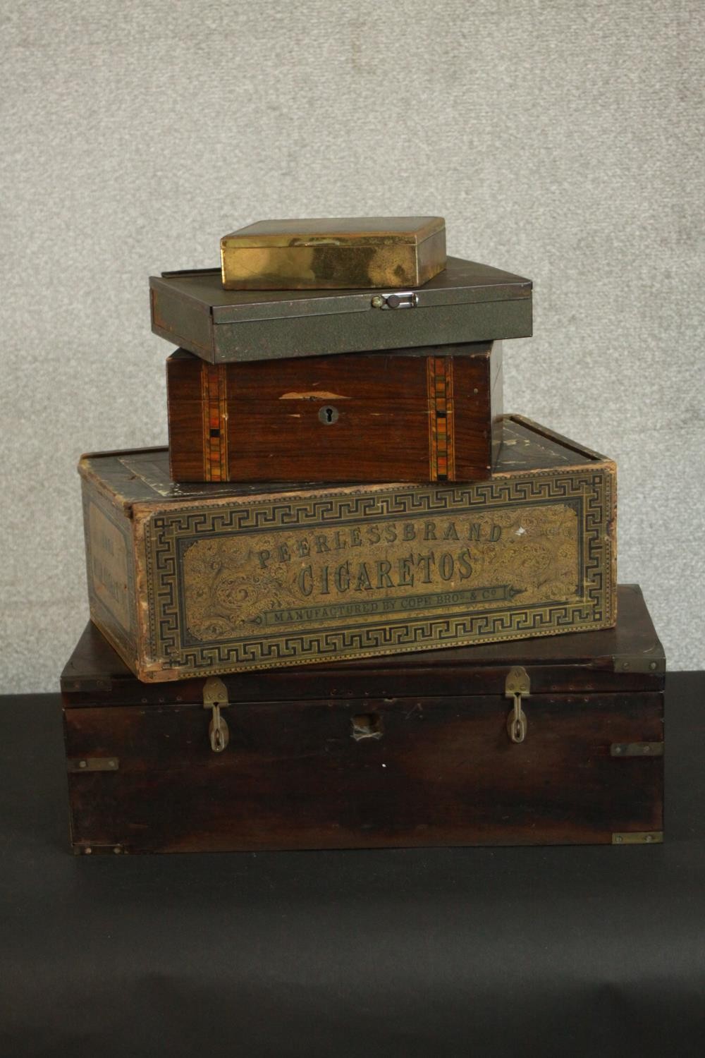 A collection of boxes, including a painted metal box, a vintage cigarette box, a large mahogany