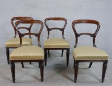 A set of four Victorian style walnut dining chairs, with gold silk upholstered overstuffed seats, on