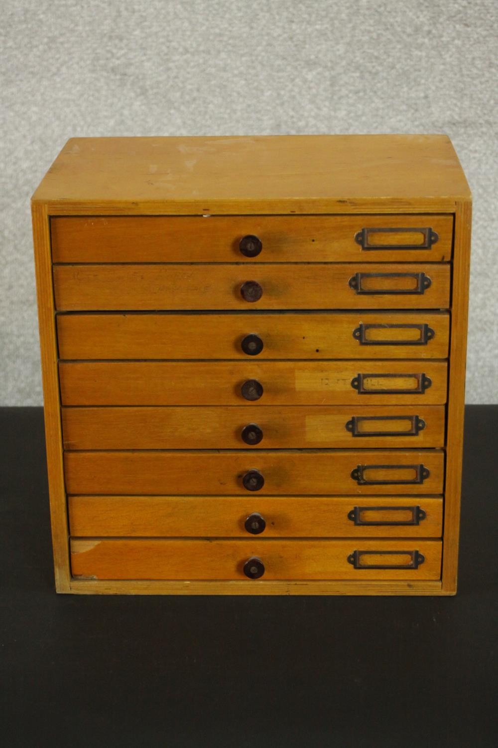 A mid 20th century birch plywood tabletop collector's cabinet of eight drawers. H.32 W.31 D.20cm.