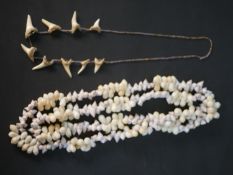 An early 20th century sharks tooth and glass bead necklace along with a long seashell necklace.