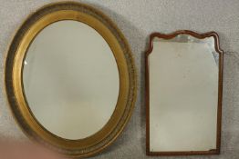 An early 20th century oval gilt mirror, with a bevelled mirror plate, together with a mahogany