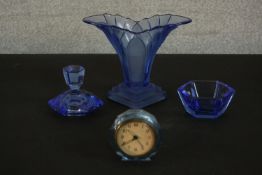 A group of circa 1930s press moulded blue glass items, including a desk clock, a vase, a bowl and