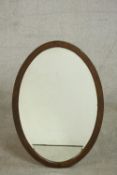 A circa 1920s oak framed oval mirror. H.84 W.57cm.