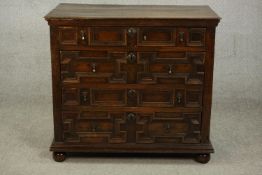 A 17th century and later Jacobean oak chest of four long drawers with geometric moulding and brass