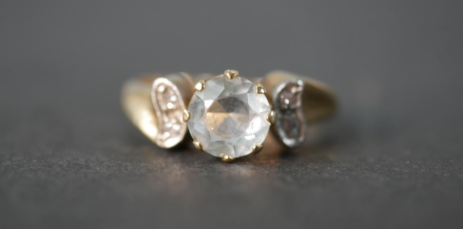 An aquamarine and diamond 14 carat gold flanked solitaire ring. Set to centre with a round mixed cut