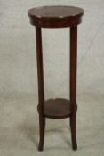 An Edwardian walnut jardiniere stand, with a circular top over a circular undertier on square