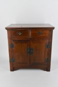 An early 20th century Chinese elm table top cabinet, with two short drawers over two cupboard