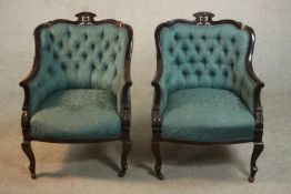 A pair of Edwardian walnut tub armchairs, upholstered in buttoned blue damask, with scrolling arms