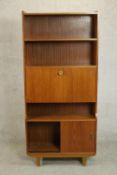 A circa 1970s teak bureau bookcase, with two shelves over a fall front enclosing pigeonholes,