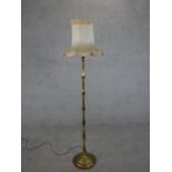 A 20th century brass standard lamp, with a multiple baluster turned stem on a circular base, with
