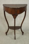 An early 20th century mahogany demi lune side table, with a foldover top opening to reveal a