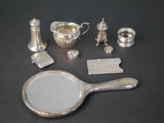 A collection of silver items, including a milk jug, salt shaker, vesta case, a card case, silver