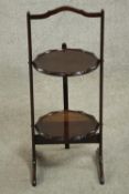 An early 20th century folding two tier cake stand. H.65 W.28 D.27cm.