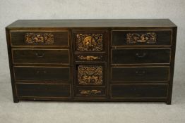 A Chinese lacquered sideboard, 20th century, with a central parcel gilt and pierced door flanked